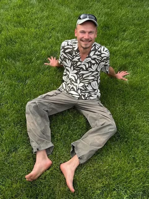 GREEN & BRIGHT Solution owner sits on the fresh lawn after the care